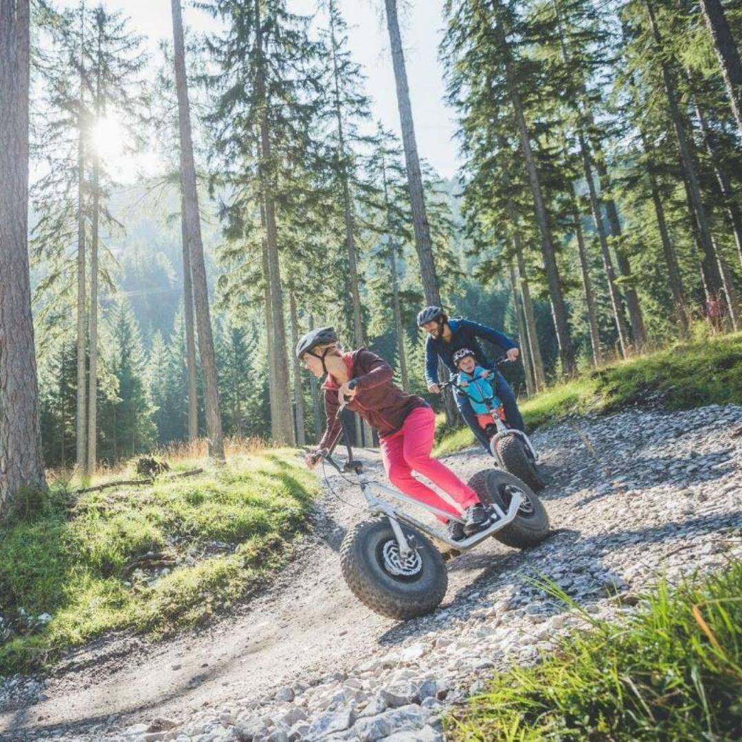 Familie fährt mit Monsterrollern durch den Wald.