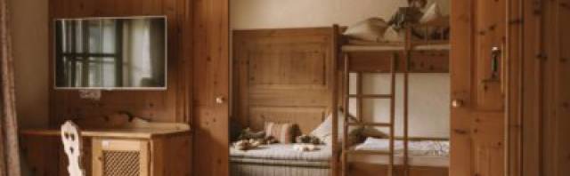 Rustikales Familienzimmer mit Stockbett aus Holz.