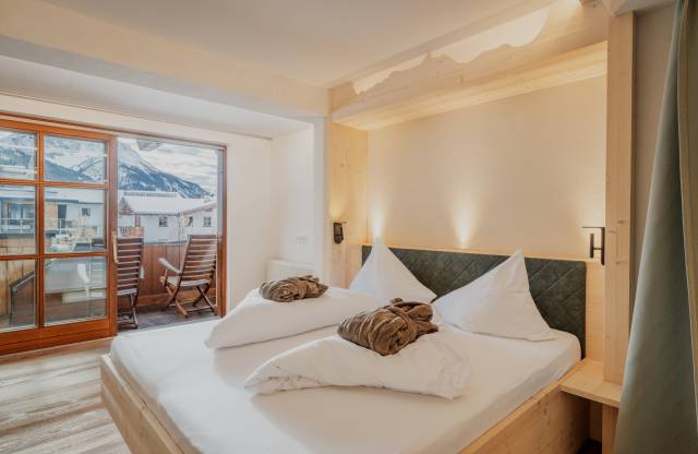 Zimmer mit Doppelbett und Balkon im Familienhotel Tirolerhof.