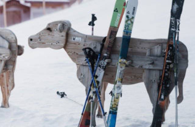 Skiablage aus Holz in Form einer Kuh im Skigebiet in Tirol.