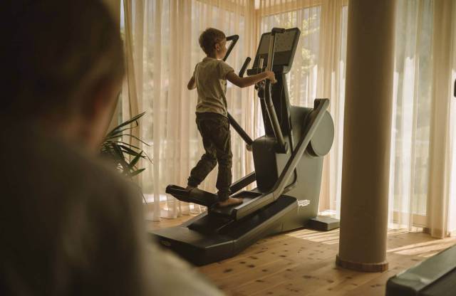 Sportlicher Junge auf dem Stepper im hauseigenen Fitnessraum im Tirolerhof.
