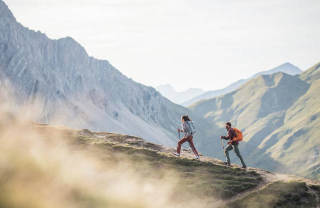 Zwei Wanderer mit Wanderstöcken in den Tiroler Bergen.