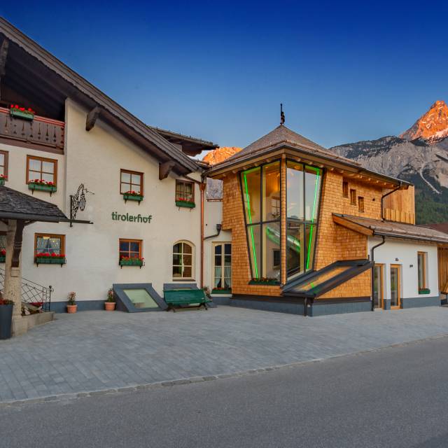 Außenansicht des Tirolerhofs von vorne mit Panoramablick auf die Berge.