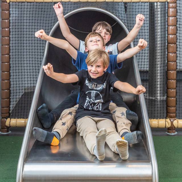 Drei Kinder auf der Indoor Rutsche im Tirolerhof.