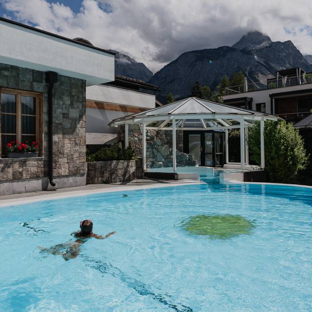 Maedchen schwimmt im Sommer im Panorama Schwimmbad des Tirolerhofs.