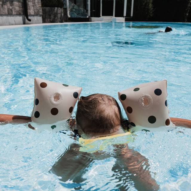 Kleinkind mit Schwimmflügel am Plantschen im Außenpool im Tirolerhof.