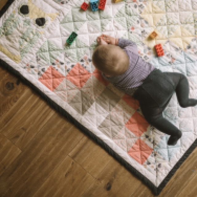 Baby lying on a play mat at the family hotel Tirolerhof.