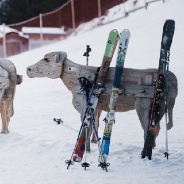 Skiablage aus Holz in Form einer Kuh im Skigebiet in Tirol.