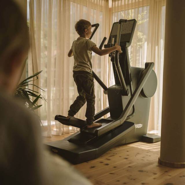 Sportlicher Junge auf dem Stepper im hauseigenen Fitnessraum im Tirolerhof.