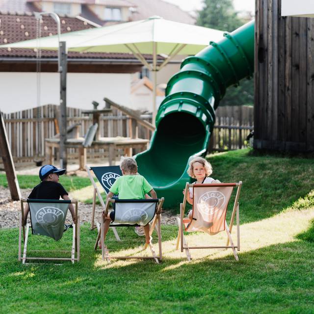 Kinder chillen im Garten auf Liegestühlen im Tirolerhof