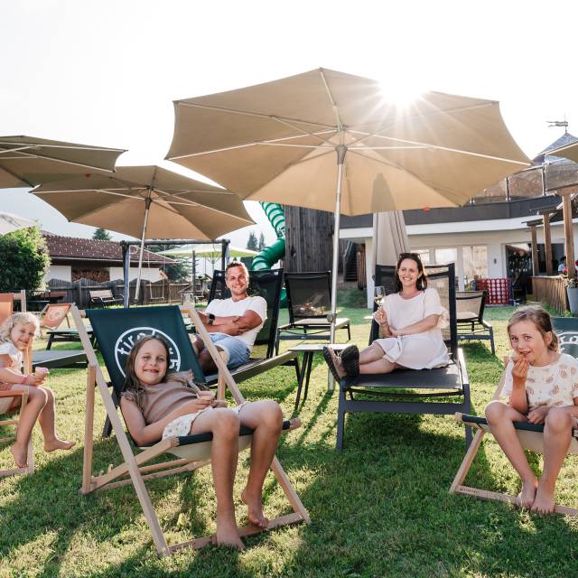Familie genießt den Garten auf Liegestühlen