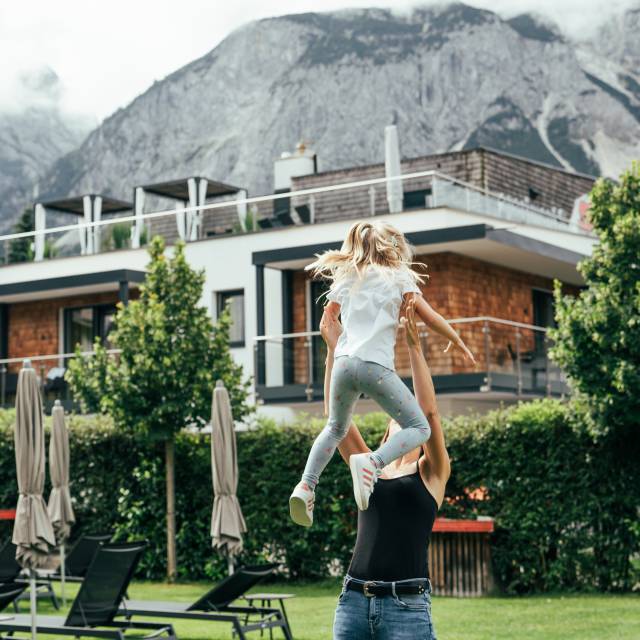 Mutter und Kind spielen im Garten 