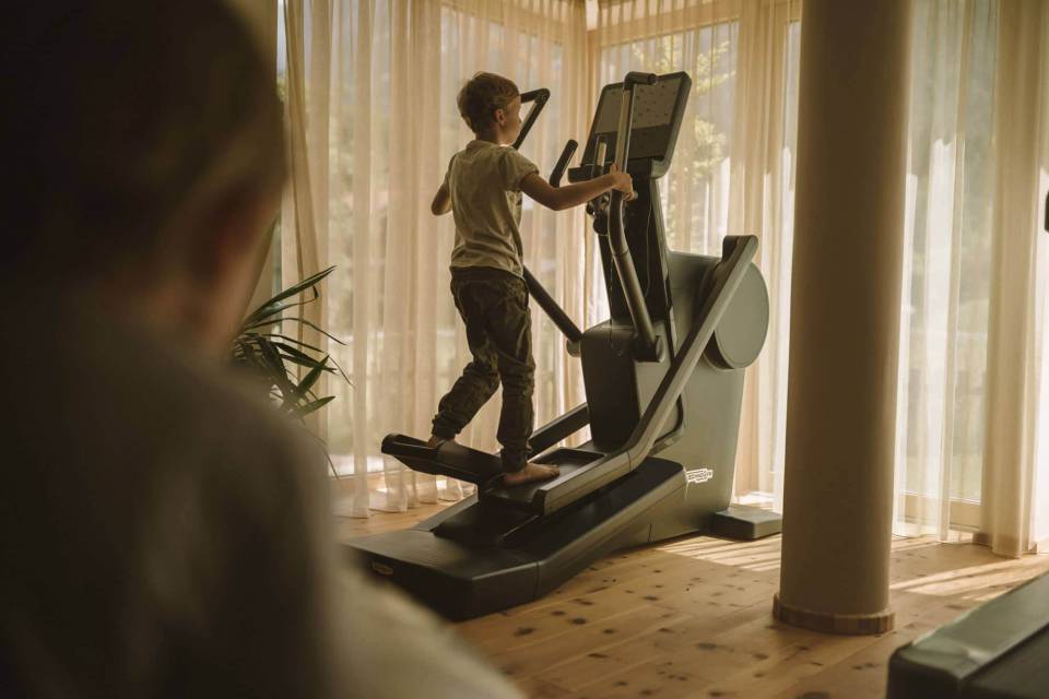 Sportlicher Junge auf dem Stepper im hauseigenen Fitnessraum im Tirolerhof.
