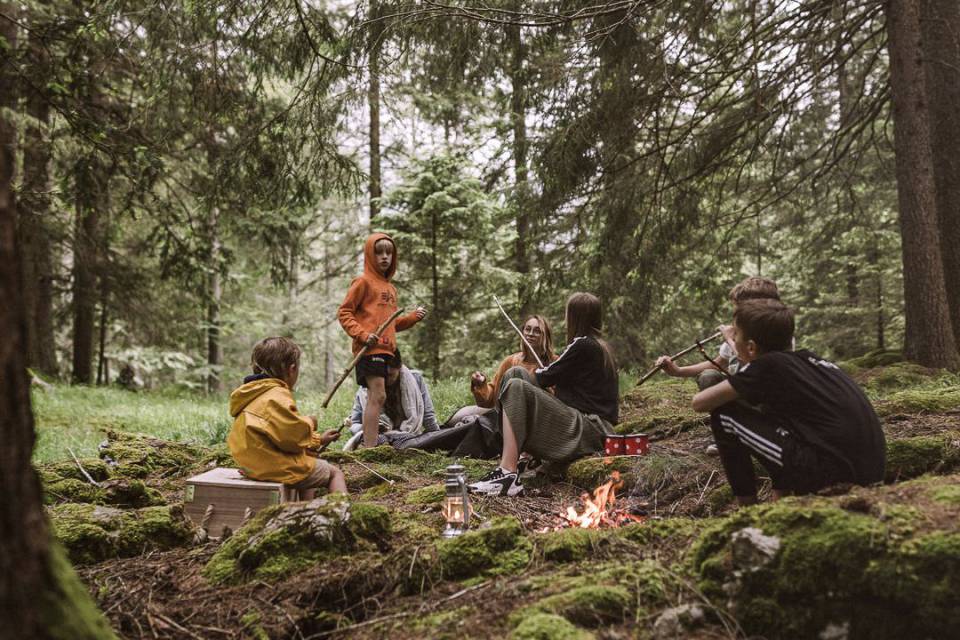 Kinder im Wald beim Feuer machen.
