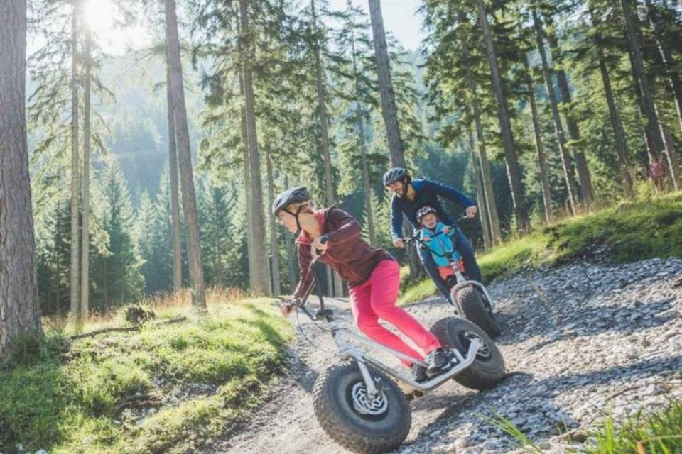 Familie fährt mit Monsterrollern durch den Wald.