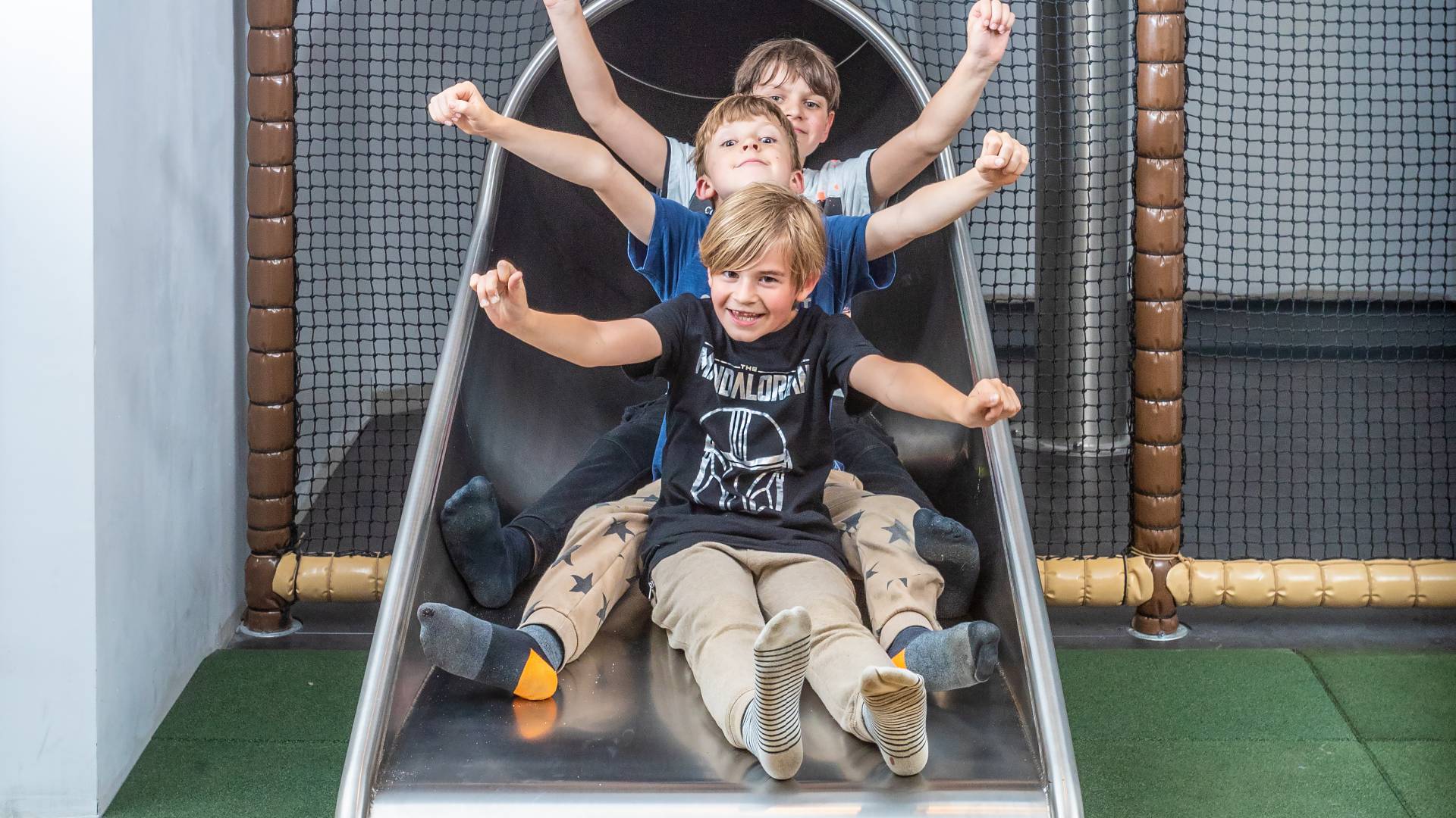 Drei Kinder auf der Indoor Rutsche im Tirolerhof.
