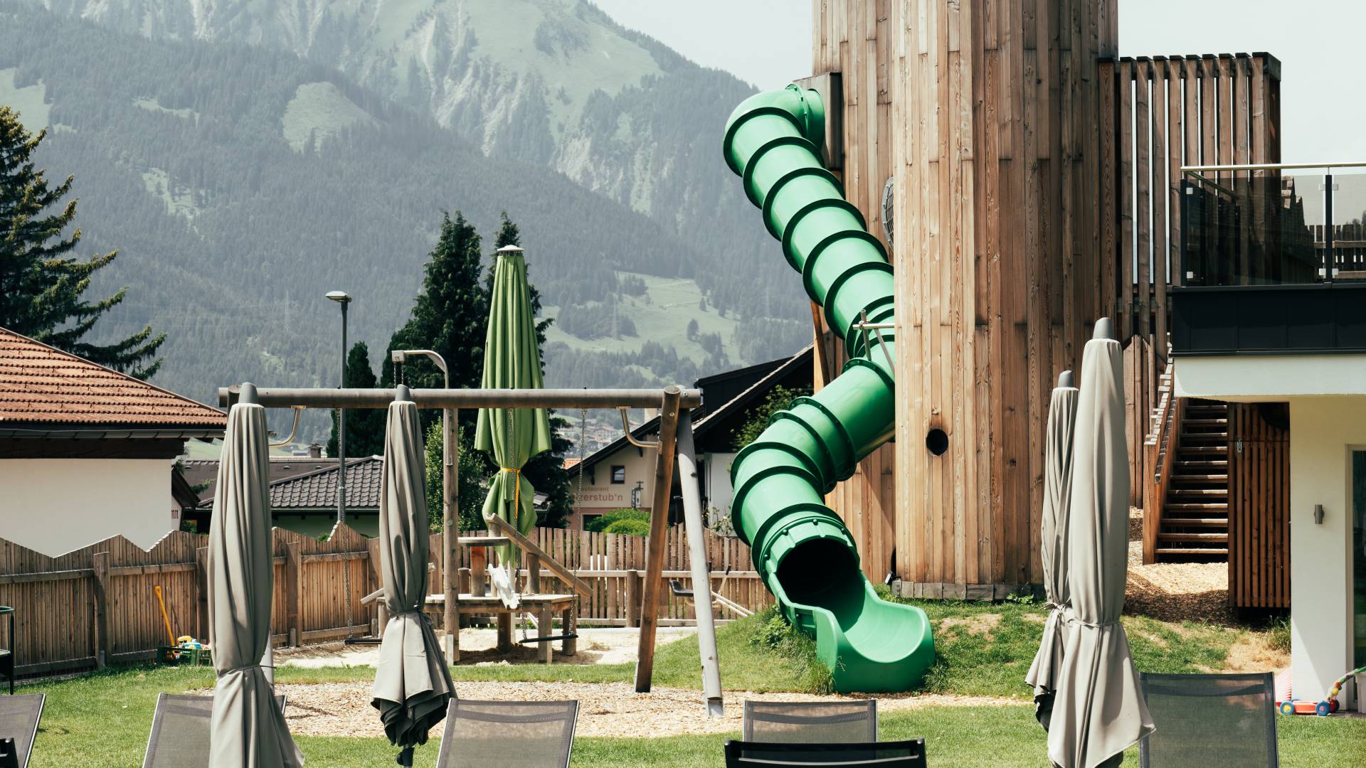 Pool und Spielplatz im Außenbereich des Hotels Tirolerhof.
