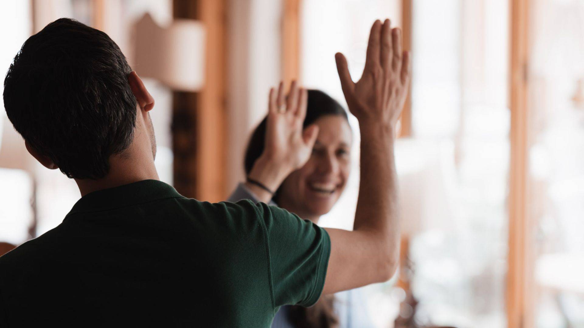 Zwei Mitarbeiter des Tirolerhofs geben sich ein High Five.